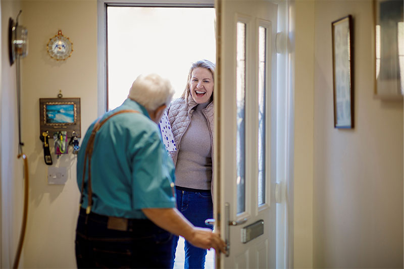 Frau zeigt Senioren etwas auf dem Smartphone