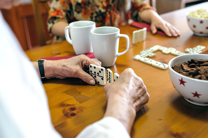 2 ältere Menschen spielen Domino